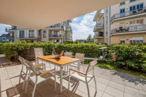 einen Tisch und Stühle auf einer Terrasse vor einem Gebäude in der Unterkunft Villa Seeadler in Börgerende-Rethwisch