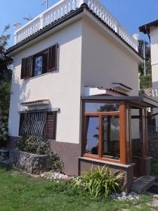 a white house with a window and a door at House H-ELIOS in Lovran