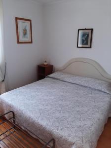 a bed in a bedroom with two pictures on the wall at House H-ELIOS in Lovran