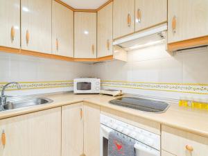 eine Küche mit einer Spüle und einer Mikrowelle in der Unterkunft My City Home- Cosy apartament in Chamberi in Madrid