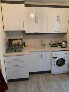 a kitchen with white cabinets and a washing machine at elisa apart 3 in Istanbul