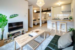 un soggiorno con un divano e un tavolo di 箱館宿 観月-Mizuki-伝統的建築物の宿-最大8名宿泊可能 a Hakodate