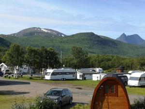 eine Gruppe von Wohnmobilen auf einem Parkplatz mit Bergen in der Unterkunft Camp Fjordbotn in Galnslåtta