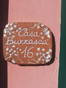a sign on the side of a pink wall at Casa Burrasca in Levanto