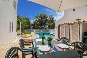 un patio con mesa, sillas y piscina en Villa Sunflower, en Albufeira