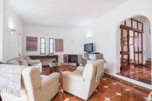 a living room with two white couches and a fireplace at Villa Sunflower in Albufeira