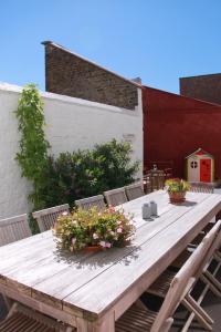 una mesa de madera con flores en el patio en Vakantiewoning Villa Elena, en Nieuwpoort