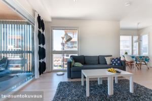 a living room with a couch and a table at The Best View in Turku with private balcony, sauna, car park in Turku