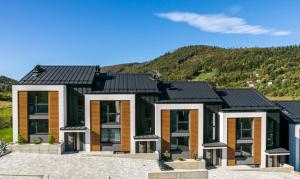 a house with a mountain in the background at Apartamenty MIWA in Szczyrk