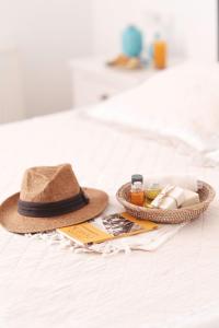 a hat and a tray of cosmetics on a bed at Gule Cunda in Ayvalık