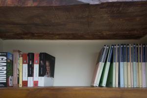 a shelf with a bunch of books on it at Iseo Portelle Holiday with private parking in Iseo