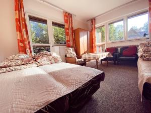 a bedroom with a bed and a table and windows at Villa Cecylia in Zakopane