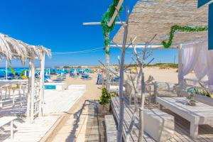a beach with a bunch of chairs and tables at Masseria Pagliamonte in San Vito dei Normanni