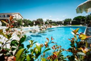 una grande piscina con acqua blu di Hotel Pulicinu a Baja Sardinia