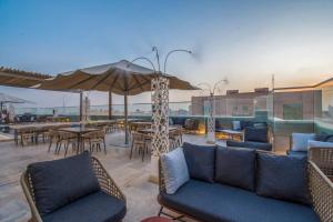 un patio con sedie, tavoli e un ombrellone di Grand Plaza Hotel - Gulf Riyadh a Riyad
