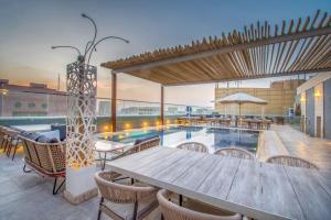 un patio con tavolo e sedie e una piscina di Grand Plaza Hotel - Gulf Riyadh a Riyad
