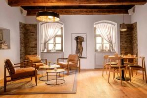 a living room with tables and chairs and a statue at Boutique hotel & spa DOMA u nás - entry AquaCity free in Poprad