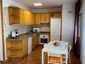 アリナガにあるBeach home Wifi/Satのキッチン(木製キャビネット、フルーツボウル付きテーブル付)