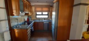 eine kleine Küche mit Holzschränken und einem Waschbecken in der Unterkunft Villa Adais in Playa Blanca
