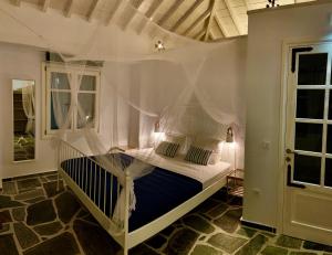 a bedroom with a bed with an umbrella on it at Kalimera homes in Skopelos Town