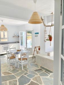 a kitchen and dining room with a table and chairs at Kalimera homes in Skopelos Town