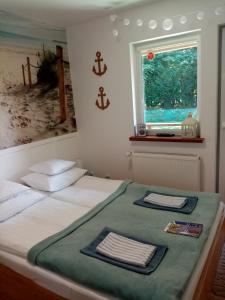 a bedroom with a bed with two towels on it at Bukowe Zacisze in Gąski