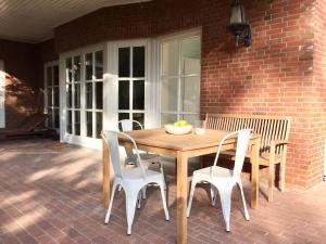 a wooden table and chairs on a patio at Uns Landhus 43 - 5 Personen in Tating