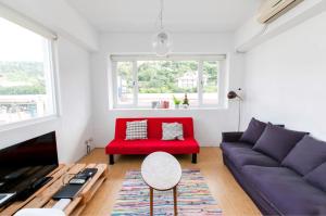 a living room with a couch and a red chair at Fun Taipei Share House 樂趣台北共居 - 月租 in Taipei