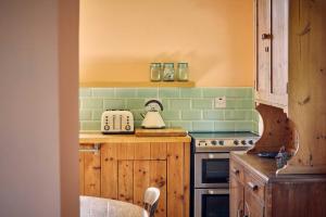 a kitchen with green tile on the wall at Host & Stay - The Red Brick Barn in Rookhope