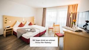 
a hotel room with two beds and a desk at City-Hotel garni in Neu-Ulm
