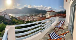 a balcony with two chairs and a view of a city at Kalimera homes in Skopelos Town