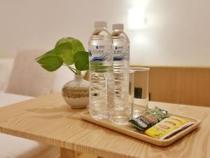 two bottles of water on a tray on a table at Hotel AONO in Chiang Mai