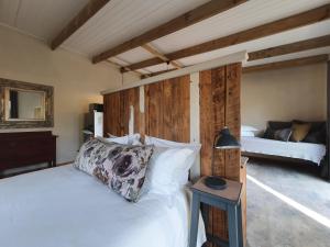 a bedroom with a white bed with a wooden headboard at Avo&Oak Guesthouse in George