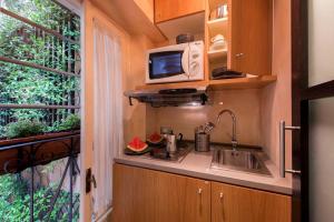 a small kitchen with a sink and a microwave at The Inn Apartments Spagna by The Goodnight Company in Rome