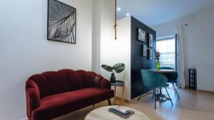 uma sala de estar com uma cadeira vermelha e uma mesa em Lineros - Apartments with shared Rooftop em Sevilha