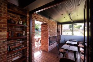 a room with a brick wall and a table and chairs at Jaspers Cabins in Pemberton