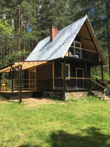 uma grande cabina de madeira com um telhado de metal em Dom w Puszczy em Supraśl