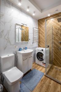 ein Badezimmer mit einem Waschbecken und einer Waschmaschine in der Unterkunft Romari Гнатюка 3 in Lwiw