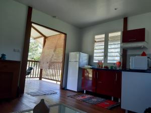 a kitchen with a refrigerator and a door to a porch at Kaz'a fred in Guenouillet