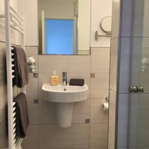 a white bathroom with a sink and a mirror at Ferienhaus Godewind in Kühlungsborn +14 photos
