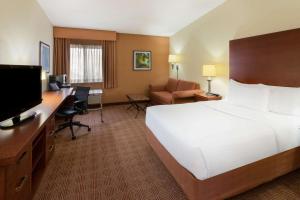 a hotel room with a bed and a desk at La Quinta Inn by Wyndham Minneapolis Airport Bloomington in Bloomington