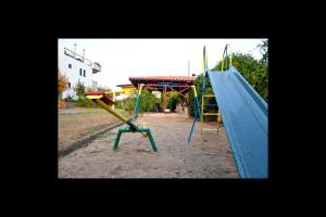 a playground with a blue slide and a play structure at Kallisti in Ormos Panagias