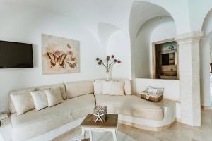 a living room with a couch and a tv at Hotel Pulicinu in Baja Sardinia