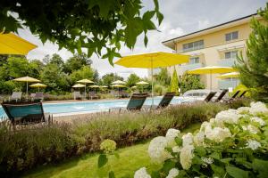 a group of chairs and umbrellas next to a pool at Hotel Garni Toscanina - Adults Only in Bad Radkersburg