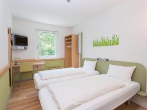 Postel nebo postele na pokoji v ubytování ibis budget Augsburg City