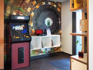 a arcade video game machine next to a wall at ibis budget Genève Petit-Lancy in Geneva