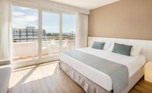 a bedroom with a large bed and a large window at Ilunion Islantilla in Islantilla