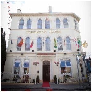 a white building with a sign that reads certon hotel at Creighton Hotel in Cluain Eois