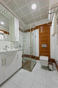 y baño con ducha, aseo y lavamanos. en Citrus Park Hotel en Antalya