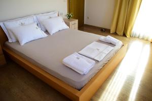 ein großes Bett mit weißen Handtüchern darüber in der Unterkunft Villa Lena in Sívas